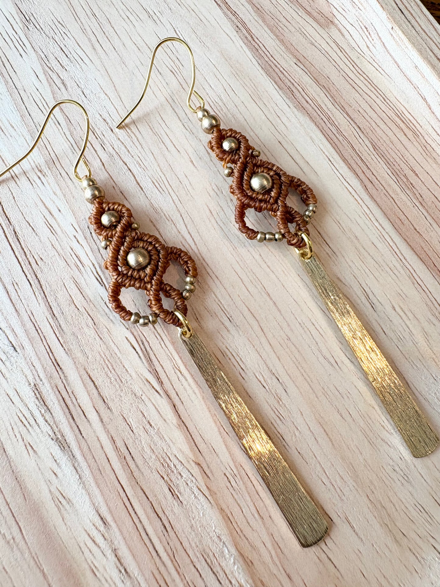 Golden rhythm - Lange handgemaakte macramé oorbellen met messing kralen en hanger